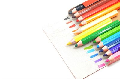 High angle view of multi colored pencils against white background