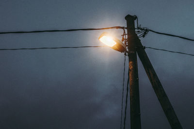 Low angle view of illuminated street light against sky