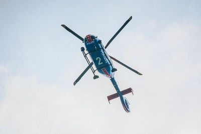 Low angle view of police helicopter flying against sky