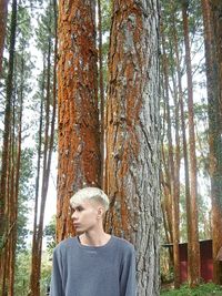 Young woman with pine tree trunk in forest