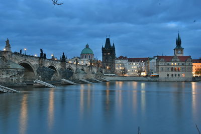 Bridge over river against buildings in city