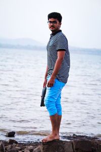 Portrait of young man standing on beach