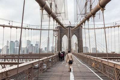 People walking on footbridge in city