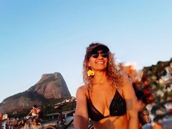 Young woman wearing sunglasses against sky