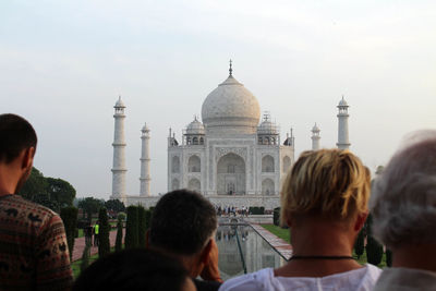 Rear view of people in front of historical building