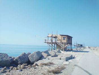 Lifeguard hut on beach against clear blue sky