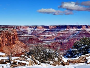 Aerial view of snowcapped landscape against blue sky