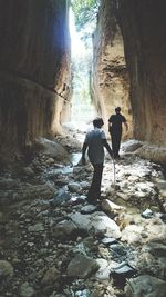 Rear view of men walking on rock