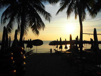 Silhouette people on beach during sunset