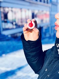 Midsection of woman blowing bubbles with wand