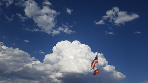 Low angle view of flag against blue sky