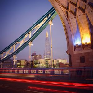 The shard seen through tower bridge in city at dusk