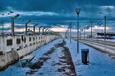 Snow covered street against sky