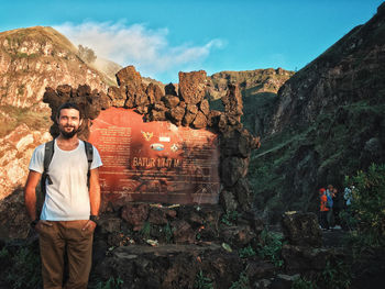 Portrait of young man standing on rock