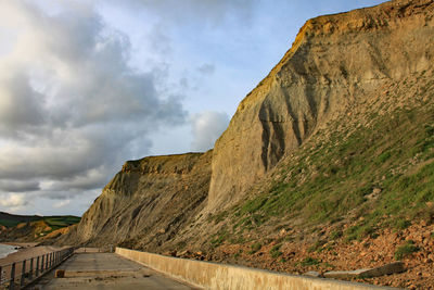 Road amidst rocks against sky