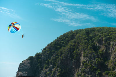 Low angle view of person paragliding against sky