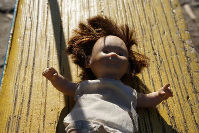 Close-up of girl with lizard on wood