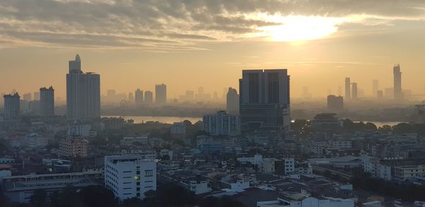 Aerial view of buildings in city during sunset