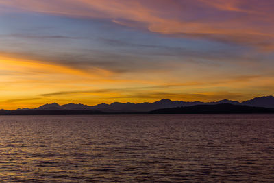 Scenic view of sea against dramatic sky during sunset