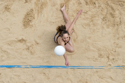 Woman with arms raised on beach