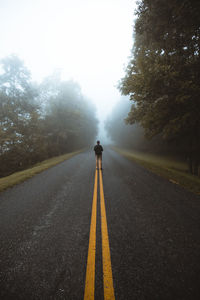 Rear view of man standing on road