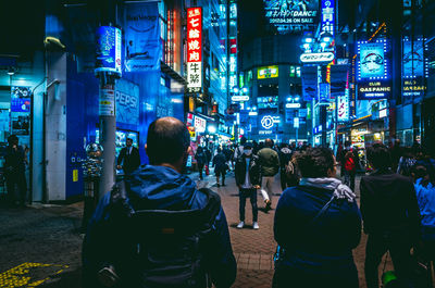 Crowd walking on city street at night