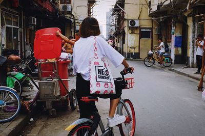 People riding bicycle on street in city