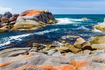 Scenic view of rocks on beach against sky