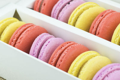 High angle view of colorful macaroons in container