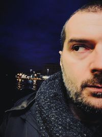 Close-up portrait of young man against sky at night