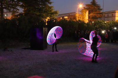 Rear view of woman on illuminated street at night