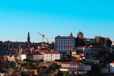 Buildings in city against clear blue sky