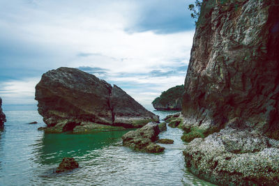 Rocks in sea against sky