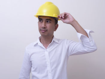 Portrait of young man wearing hat against white background