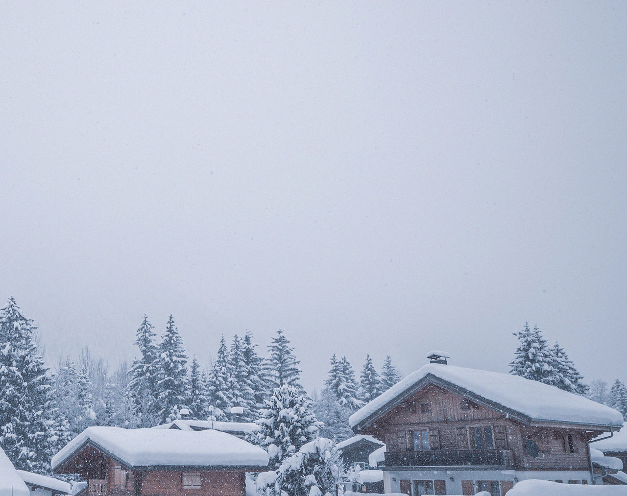 SNOW COVERED HOUSES AGAINST CLEAR SKY