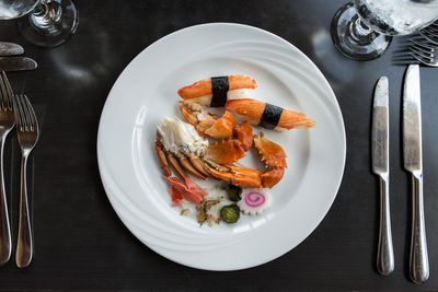 Place setting with crab sticks in plate on dinner table