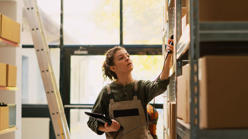 Portrait of young woman standing in factory