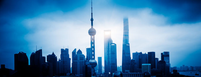 View of buildings in city against cloudy sky