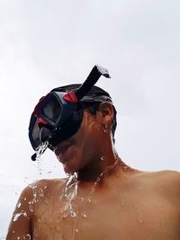 Man wearing sunglasses in water against sky