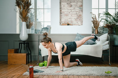 Full length of woman sitting on floor at home