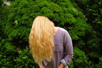 Woman covering face with long blond hair