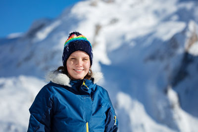 Portrait of smiling young woman standing on snow