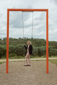 Full length of woman on swing against sky