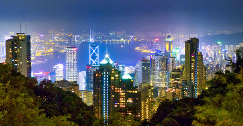 Illuminated buildings in city against sky at night