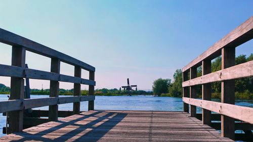 Pier over lake against clear sky