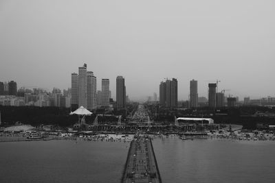 City at waterfront against clear sky