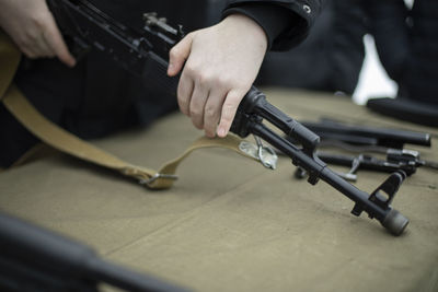 Midsection of man holding gun