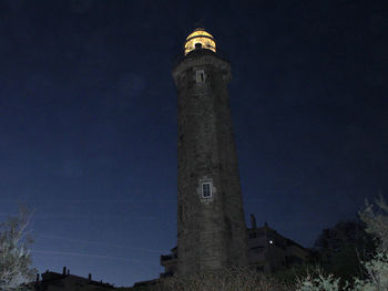 Low angle view of lighthouse against sky at night