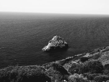 High angle view of rock in sea against sky