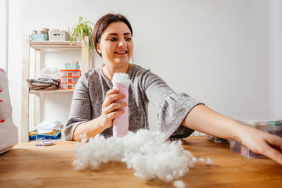 Portrait of woman sitting on table at home